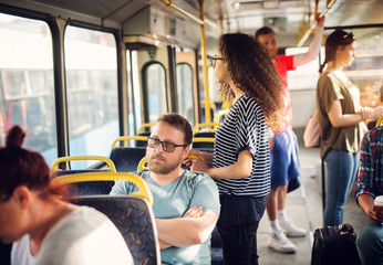 Nervous man is sitting in a bus and waiting to get to his destination.