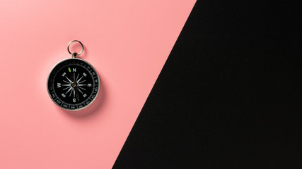 compass on pink and black paper background.