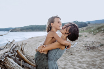 Mother and son having fun at the beach in the evening