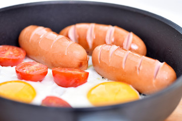 Fried sausages in a frying pan. Breakfast on the table. Tasty food.