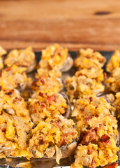Top view, close distance of homemade, preparation of rows of raw clam casino in clam shells on aluminum foil, ready to be baked