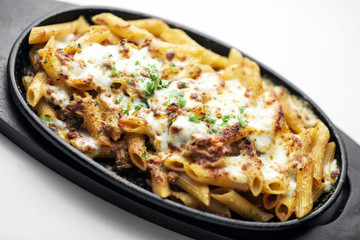 oven baked fresh pasta penne bolognese and mozzarella cheese dish