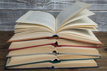 pile of open books on a wooden background Concept of education, library, information retrieval, back to school