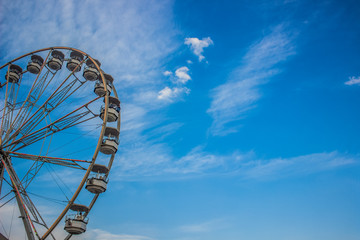 entertainment carnival concept of ferris wheel on blue sky cloud background with empty space for...