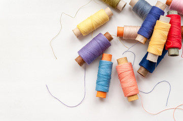 Reels of colorful threads on a white background