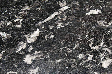 Polished surface of a black marble with white veins slab