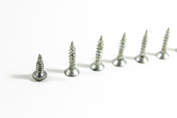 Close-up top shoot of multiple screws on white blurry background