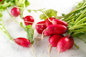fresh harvest of young radishes with tops on white background. Closeup