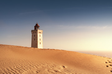Beautiful summer sunset over the sand dunes and famous lighthouse with ocean view. Rubjerg Knude Lighthouse, Lønstrup in North Jutland in Denmark, Skagerrak, North Sea