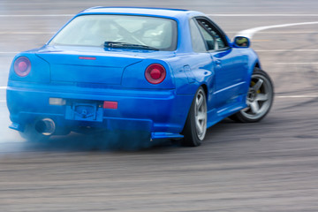 Motion blur car drifting, Professional driver drifting car on race track with smoking.