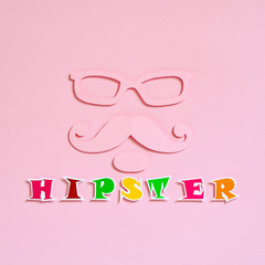 Hipster cut from paper on a pink textured background, top view. Glasses, mustache and beard. Flat lay