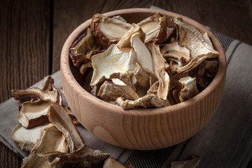 Dried mushrooms in wooden bowl.
