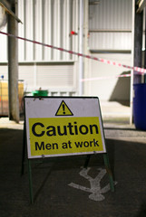 Men at work sign in an industrial work place environment.