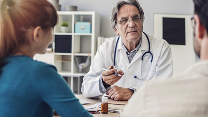 Doctor talking a young couple of patients