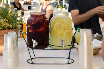Two bottles of lemonade on the table at the wedding are one red, the other is yellow