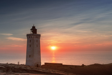 Fototapeta na wymiar Beautiful sunset view of the lighthouse and sand desert dunes and ocean. Rubjerg Knude Lighthouse, Lønstrup in North Jutland in Denmark, Skagerrak, North Sea