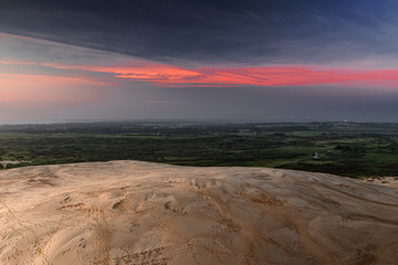 Dramatic evening sky with red clouds and sand dunes. Rubjerg Knude Lighthouse, Lønstrup in North Jutland in Denmark, Skagerrak, North Sea