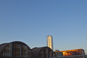 Obraz premium The topes of the rusty tankers and smoke stacks at the old little factory. 