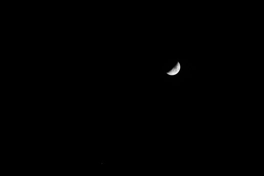 Fototapeta Crescent moon in the dark night with visible craters