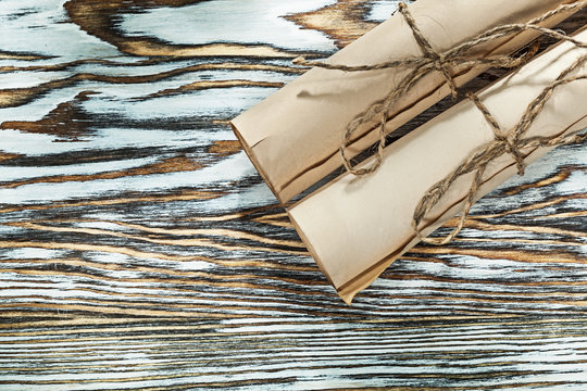 Vintage corded paper rolls on wooden board