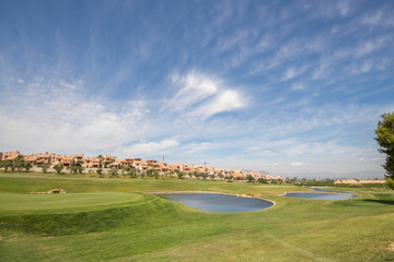 Green, lakes and luxury houses at a golf course on the Costa Blanca on a sunny summer day in Spain