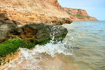 Naklejka premium beautiful sea landscape, closeup of stone on the beach, sea coast with high hills, wild nature