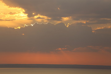 Beautiful sunset with clouds of orange and yellow in the ocean, the river
