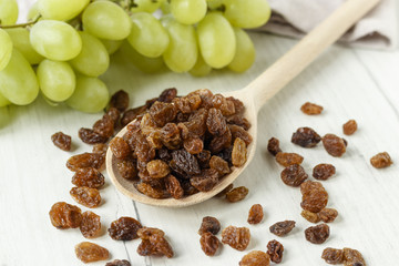 a bunch of grapes and raisins on a white background