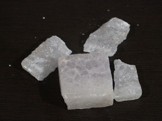 A lump of alum crystal. Alum is a very good chemical compound that is used as a medicine and for beauty treatment. Alum in Wooden Background, Fitkari