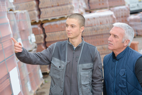 Worker Showing Building Materials To Customer