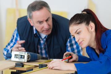 Fototapeta premium young female worker using tape measure supervisor talking aggressively