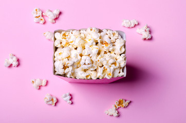 Fototapeta na wymiar Paper box with popcorn on pink background