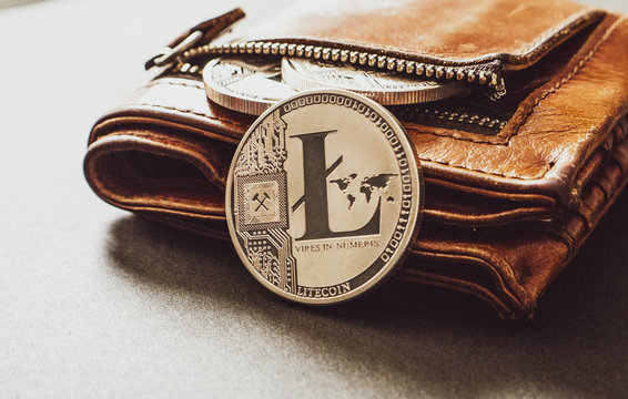 Silver Litcoin coins in a leather wallet on a plain surface