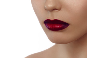 Extreme close up on model with dark red lipstick. Makeup. Professional fashion retro make-up. Dark red lipstick. Sexy lips with red ombre style lipstick on tanned skin © evgeniyasht19