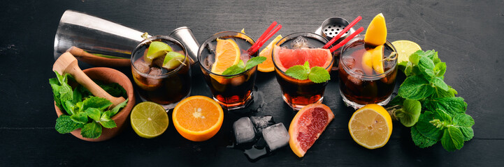 Cocktails with citrus fruit and mint. Lemon, grapefruit, lime, orange. On a wooden background. Top...