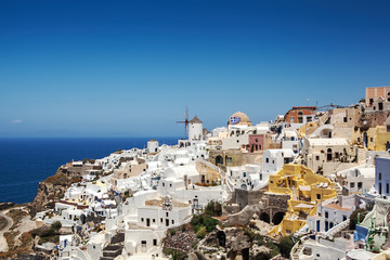 Fototapeta na wymiar Most Romantic Greek Oia town on Santorini island, Greece. Traditional and famous houses and churches with blue domes over the Caldera, Aegean sea. Santorini classically Thera and officially Thira.