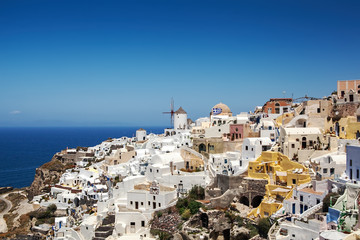 Most Romantic Greek Oia town on Santorini island, Greece. Traditional and famous houses and churches with blue domes over the Caldera, Aegean sea. Santorini classically Thera and officially Thira.