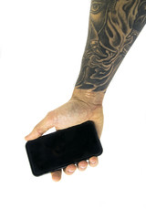 Studio shot with a hand holding a device with forearm tattooed
