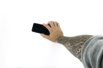 Studio shot with a hand holding a device with forearm tattooed
