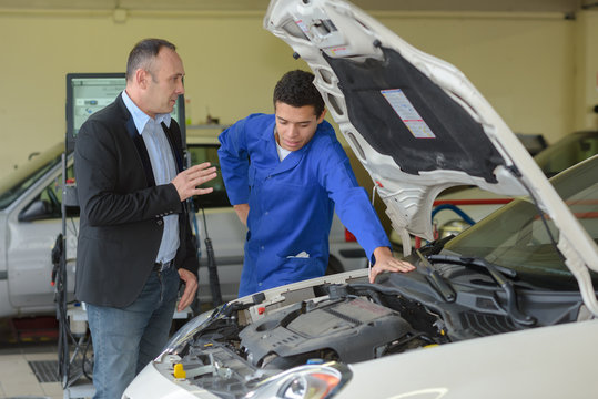 car mechanic talking with customer