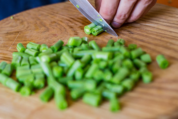 Coocking of green beans and garlic, fresh vegatables on wooden table