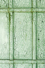 abstract wooden wooden door background with cracks on green plaster paint.
