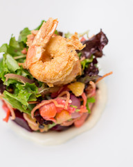 A prawn salad with beets on a white plate.