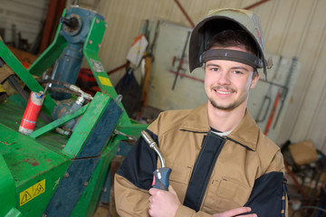 happy apprentice welder at work in the plant