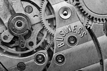 Background with the inscription BUSINESS. Black white background with metal cogwheels clockwork. Macro. 