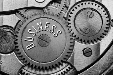 Background with the inscription BUSINESS. Black white background with metal cogwheels clockwork. Macro. 