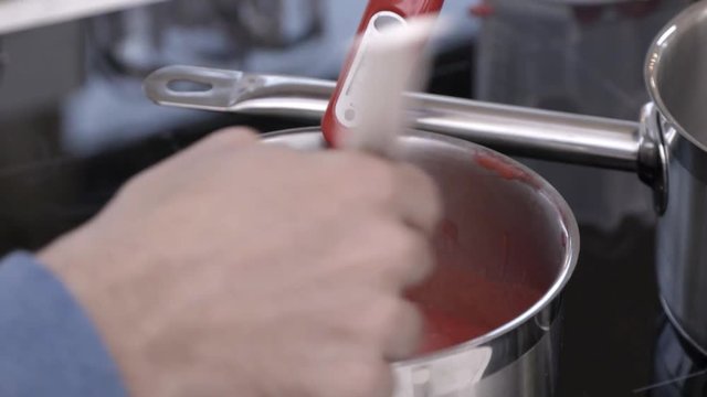 Pastry chef check temperature of the cream in the pot