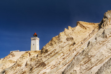 Fototapeta na wymiar Sand cliffs and sand dunes with the famous lighthouse seen from the danish beach. Rubjerg Knude Lighthouse, Lønstrup and Lokken in North Jutland in Denmark, Skagerrak, North Sea
