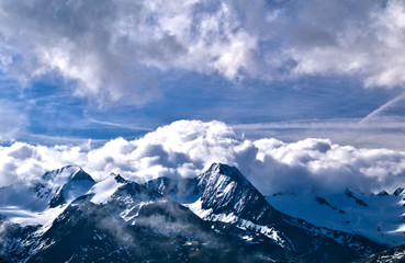 wał chmur nad ośnieżonymi szczytami Alp