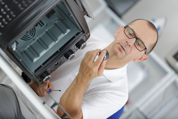 Obraz premium man repairing micro wave oven